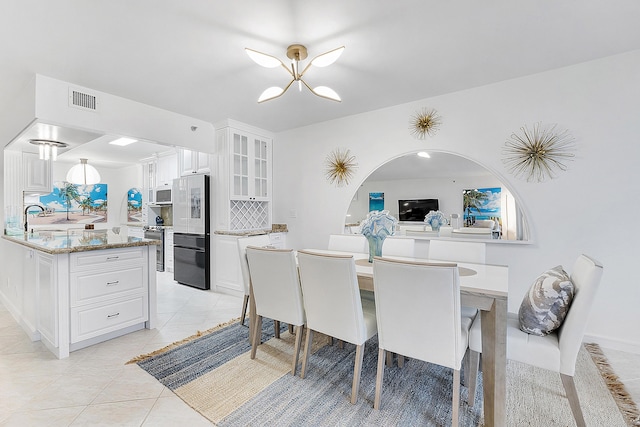 tiled dining area featuring sink and a chandelier