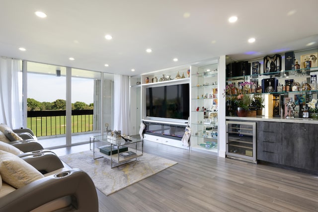 living room featuring bar area, light hardwood / wood-style flooring, expansive windows, and beverage cooler