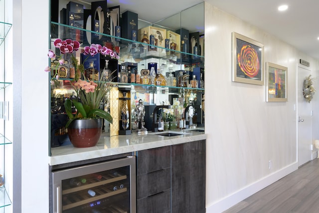 bar with wood-type flooring, beverage cooler, and sink