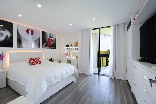 bedroom with dark hardwood / wood-style flooring, access to exterior, and a wall of windows