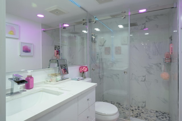 bathroom featuring an enclosed shower, vanity, and toilet