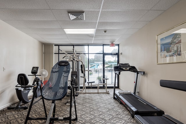 gym featuring floor to ceiling windows and a drop ceiling