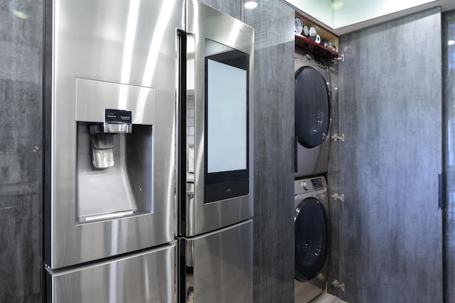 clothes washing area featuring stacked washer / dryer