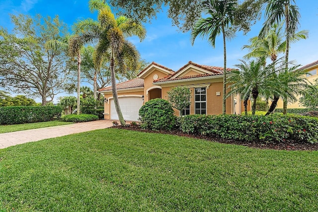 mediterranean / spanish house with a garage and a front yard