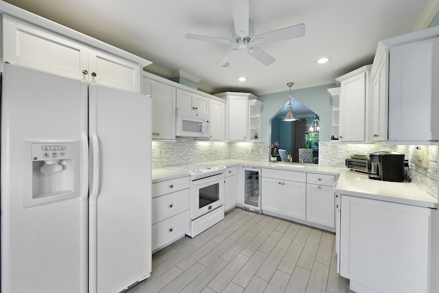 kitchen with decorative backsplash, white appliances, beverage cooler, pendant lighting, and white cabinets