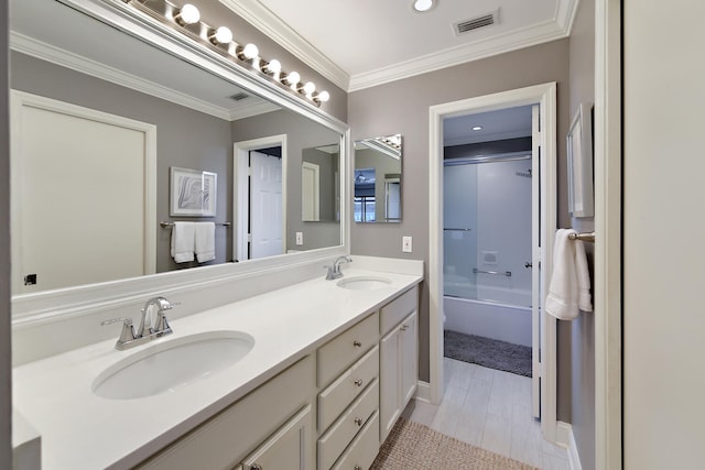 bathroom featuring shower / bath combination with glass door, vanity, and crown molding