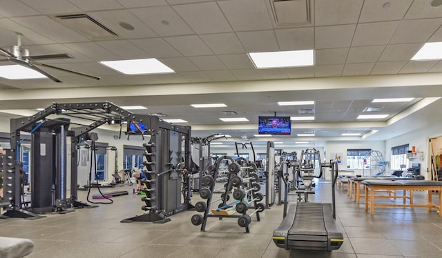 exercise room with a paneled ceiling and ceiling fan