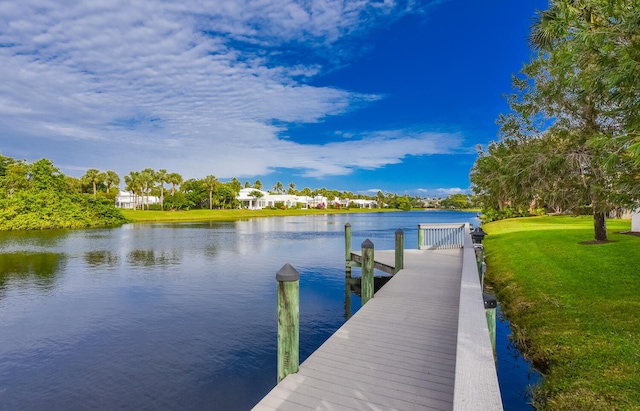 view of dock featuring a lawn and a water view