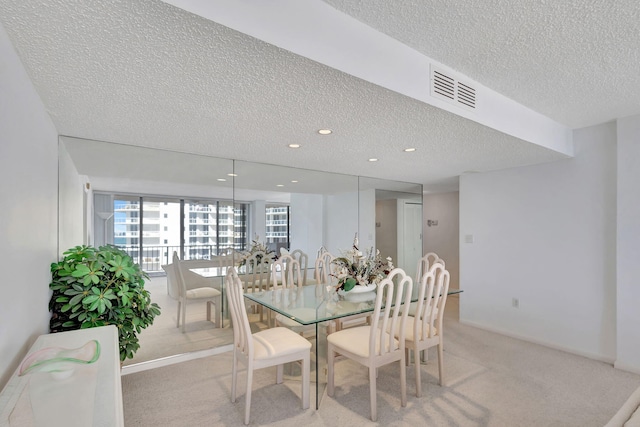 carpeted dining space with a textured ceiling