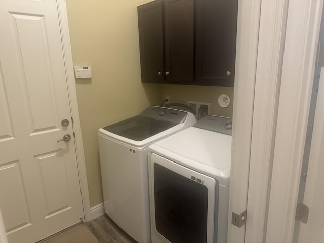 washroom with cabinets, dark hardwood / wood-style floors, and independent washer and dryer