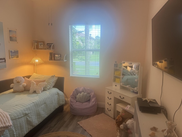 bedroom with multiple windows and dark wood-type flooring