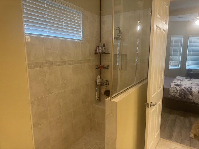 bathroom featuring tiled shower, tile patterned floors, and ceiling fan