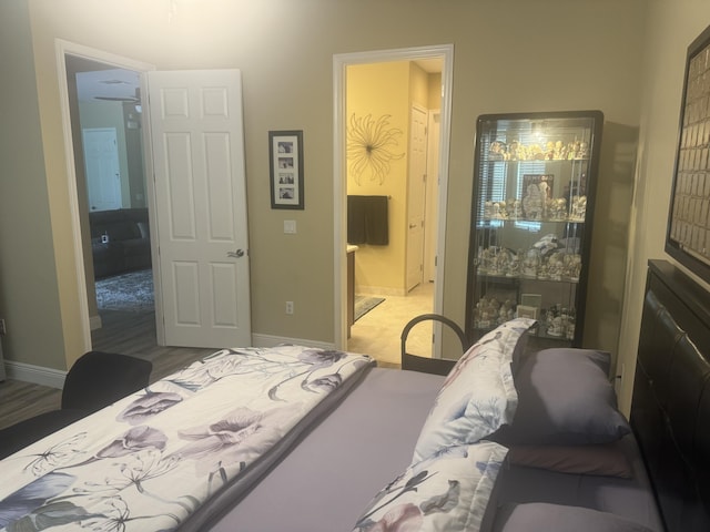 bedroom with ensuite bathroom and hardwood / wood-style flooring