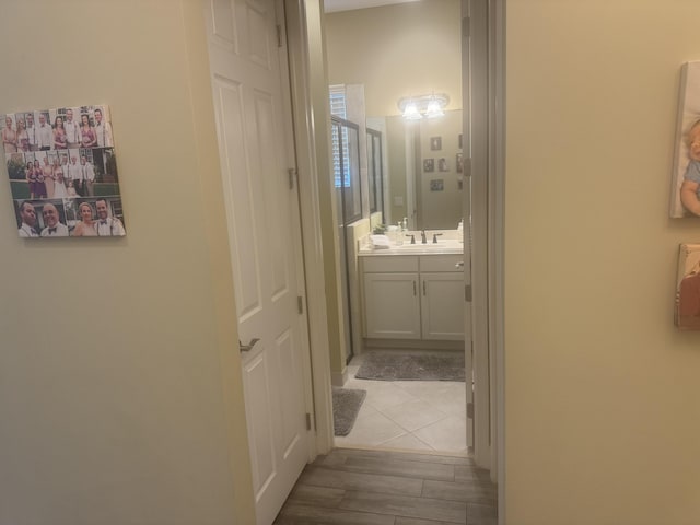 hall with light wood-type flooring and sink