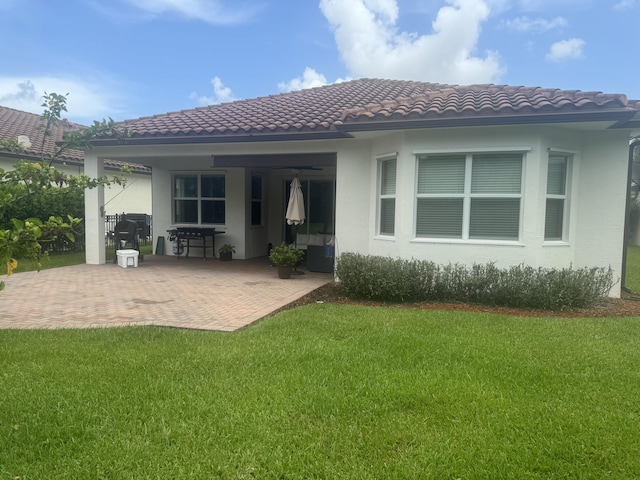 rear view of property with a yard and a patio