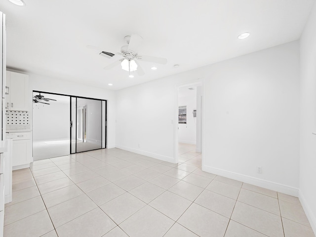 unfurnished room with ceiling fan and light tile patterned floors