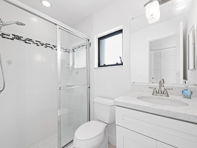 bathroom featuring toilet, an enclosed shower, and vanity