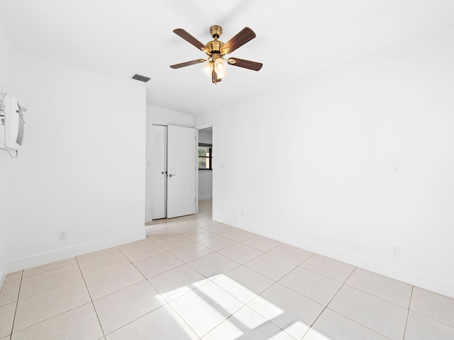 empty room featuring ceiling fan and light tile patterned floors