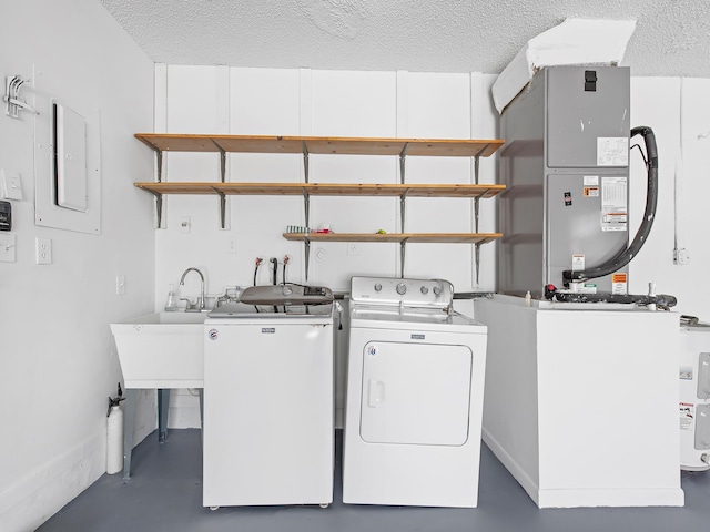 laundry area with sink, a textured ceiling, separate washer and dryer, and electric panel