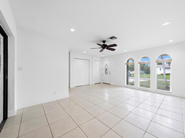 empty room with ceiling fan and light tile patterned flooring