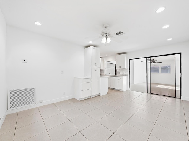 unfurnished living room featuring light tile patterned flooring and ceiling fan