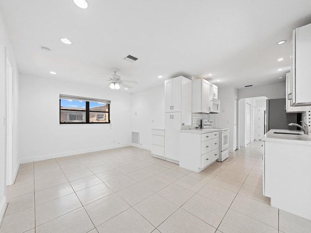 kitchen featuring sink, white cabinets, white appliances, light tile patterned flooring, and ceiling fan