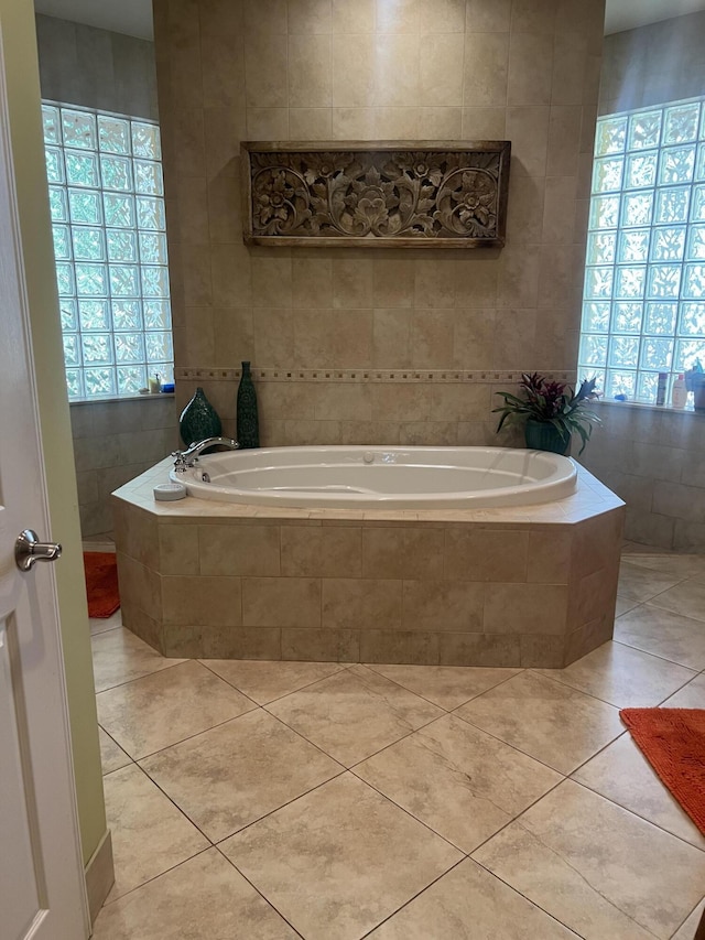 bathroom with tile walls, tile patterned floors, and tiled bath