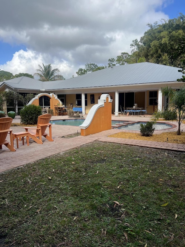 rear view of house featuring a yard and a patio