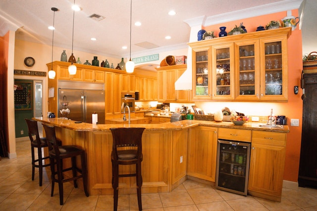 12858 153rd Ct N, Jupiter, FL 33478 - kitchen with light stone countertops, a sink, wine cooler, a kitchen bar, and appliances with stainless steel finishes