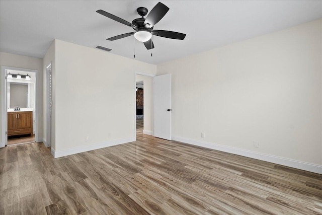 unfurnished bedroom with sink, ensuite bath, ceiling fan, and light hardwood / wood-style floors