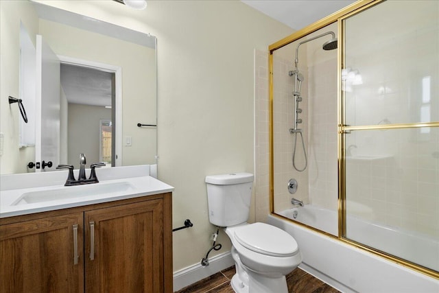 full bathroom with shower / bath combination with glass door, toilet, hardwood / wood-style floors, and vanity