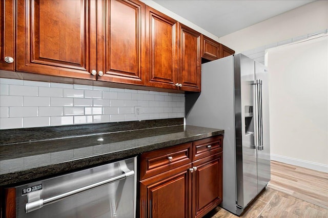 kitchen featuring stainless steel appliances and dark stone countertops