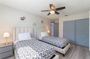 bedroom featuring hardwood / wood-style floors, ceiling fan, and a closet