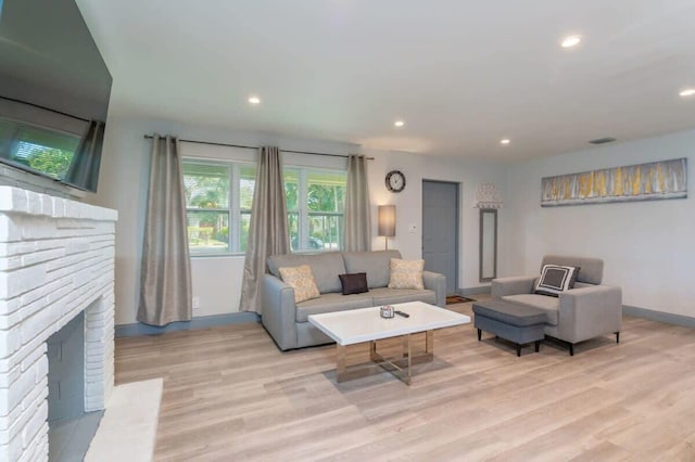 living room with light hardwood / wood-style floors and a fireplace