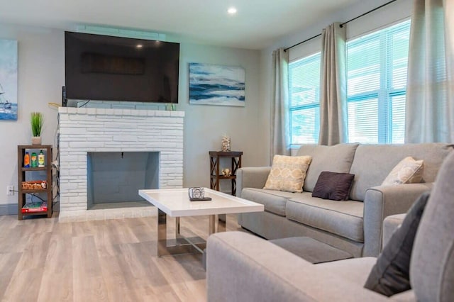 living room with a fireplace and light hardwood / wood-style flooring