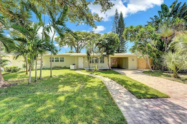 ranch-style home featuring a carport and a front lawn