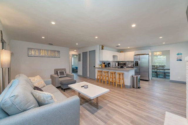 living room featuring light hardwood / wood-style floors and sink