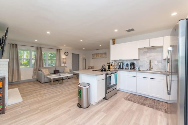 kitchen featuring kitchen peninsula, white cabinets, stainless steel appliances, and light hardwood / wood-style floors