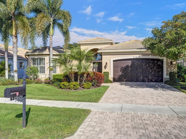 mediterranean / spanish house with a garage and a front yard