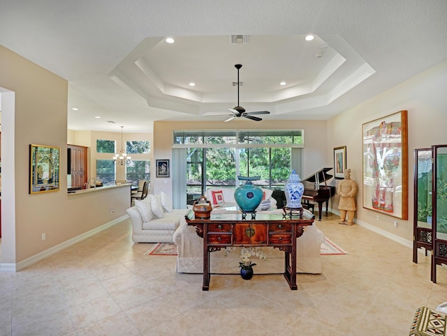 game room with ceiling fan with notable chandelier, a raised ceiling, and light tile patterned floors