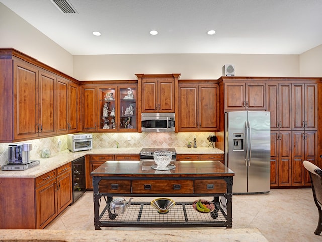 kitchen with light tile patterned floors, stainless steel appliances, wine cooler, and tasteful backsplash