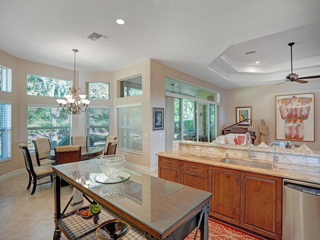 kitchen with dishwasher, sink, hanging light fixtures, a tray ceiling, and plenty of natural light