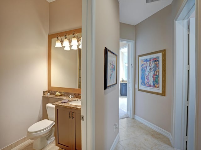 bathroom with tile patterned flooring, vanity, and toilet