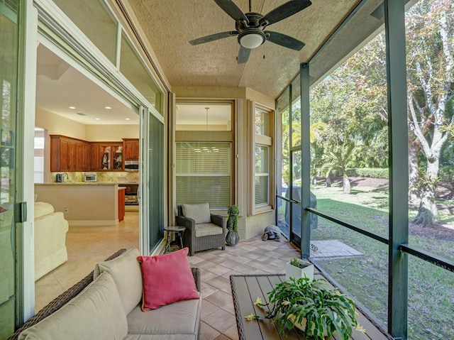 sunroom / solarium featuring ceiling fan