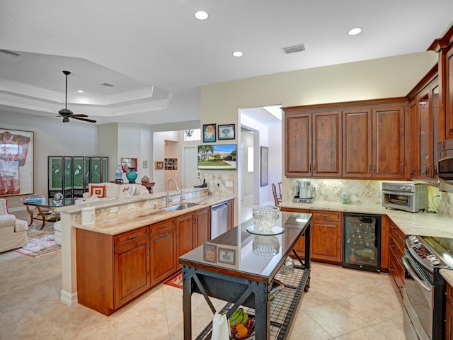 kitchen with light stone countertops, appliances with stainless steel finishes, beverage cooler, sink, and light tile patterned floors