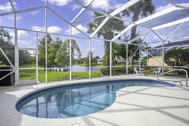 view of swimming pool featuring a patio, a water view, glass enclosure, and a lawn