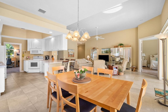 dining space featuring a towering ceiling, light tile patterned floors, and ceiling fan with notable chandelier