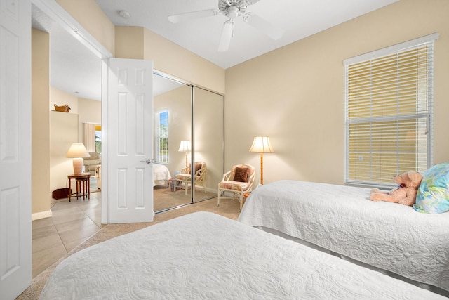 bedroom featuring light tile patterned floors, a closet, and ceiling fan