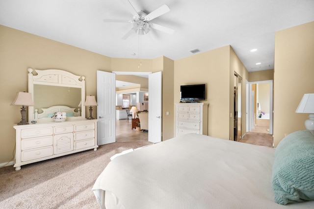 carpeted bedroom featuring ceiling fan and ensuite bath