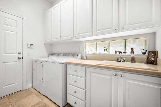 laundry area with cabinets, washer and clothes dryer, and sink